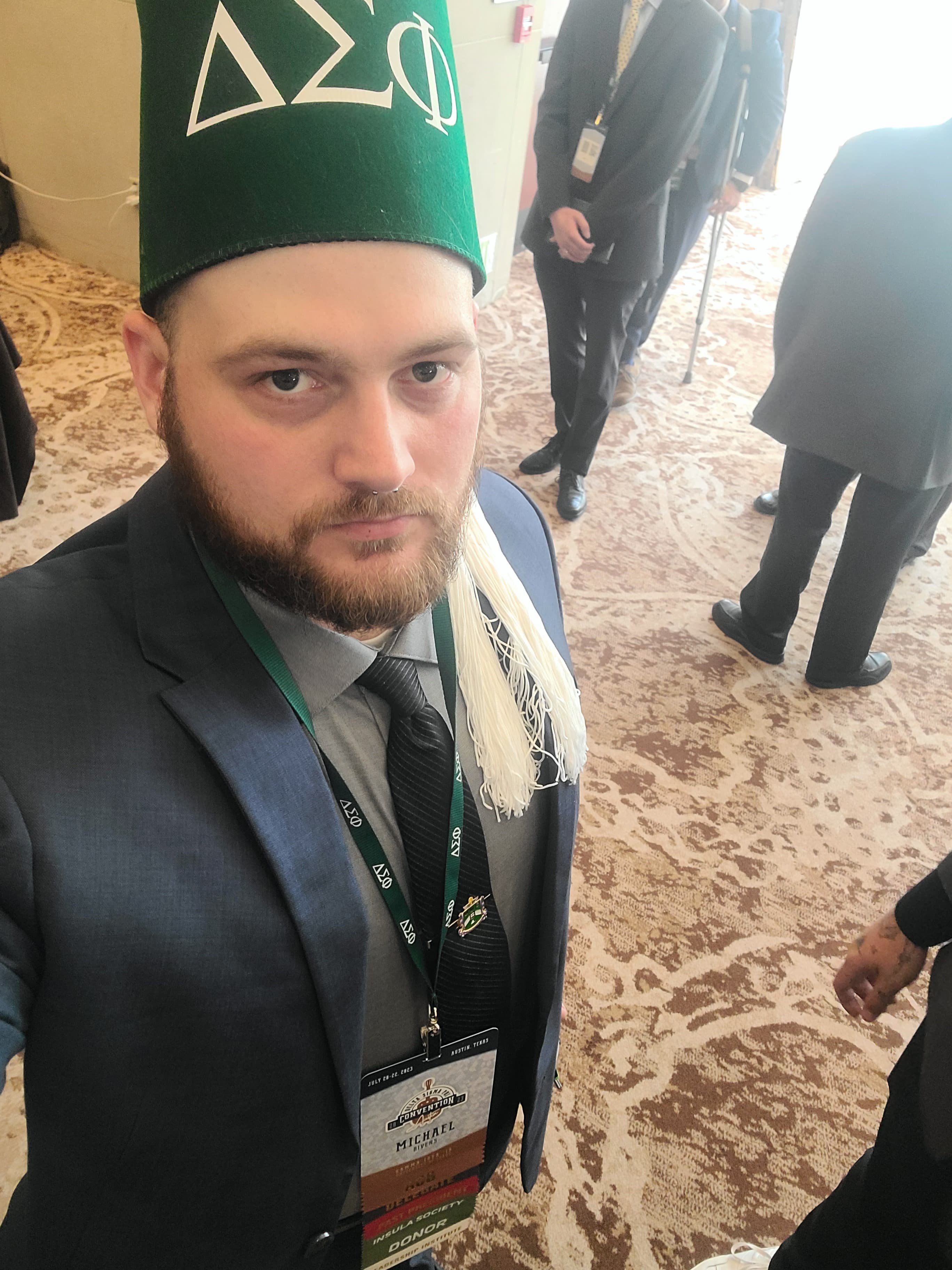 picture of Michael in a suit, wearing fraternity garb